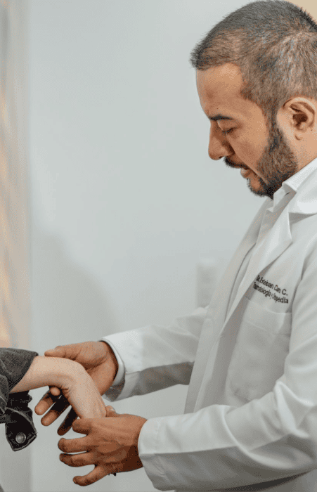Dr. Esteban Castro examinando el hombro de un paciente